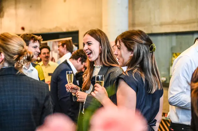 Two guests laughing over a glass during the reception.
