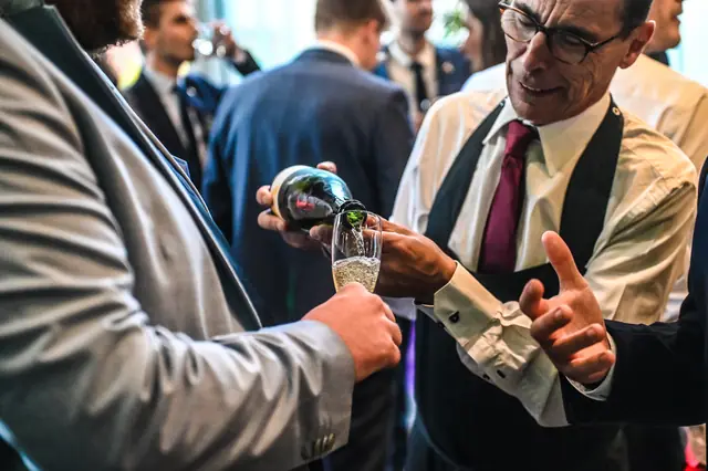 A waiter pouring bubbly for a guest.