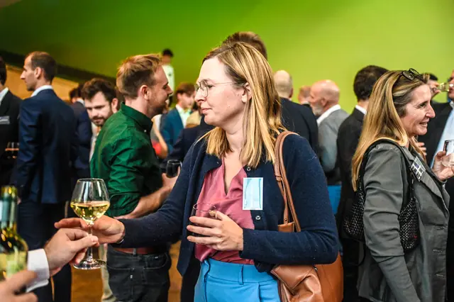 A guest being handed a glass of white wine.