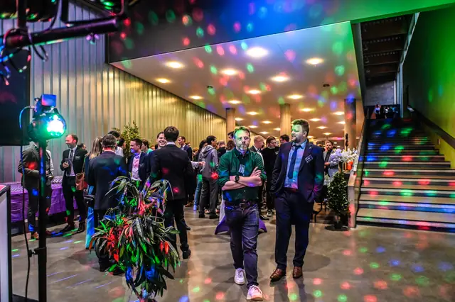 The foyer under disco lights, at the foot of the stairs.