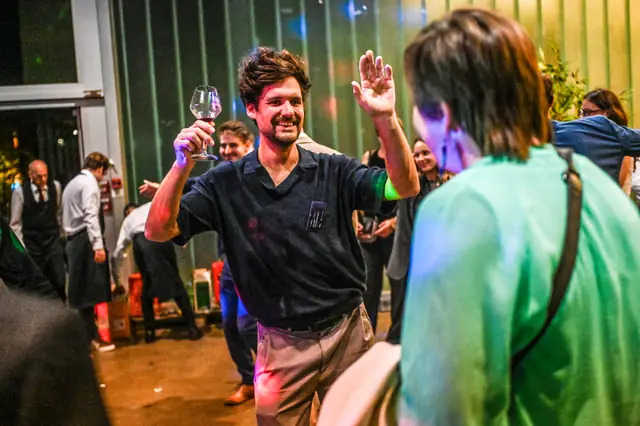 A guest raising a glass on the dance floor.